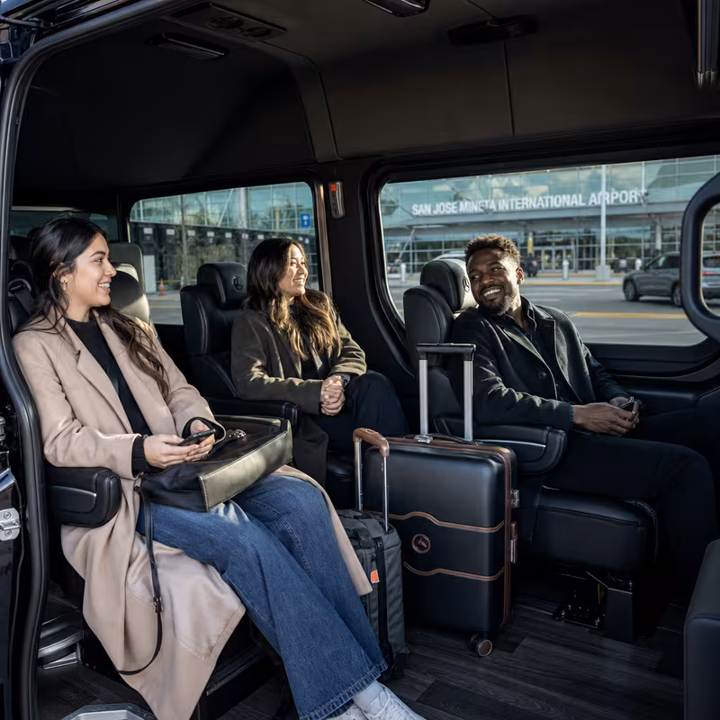 Passengers loading luggage while boarding an San Jose group shuttle