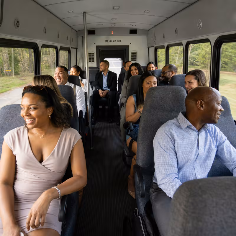 Group boarding a white charter bus for Private Event Transportation transportation in San Jose