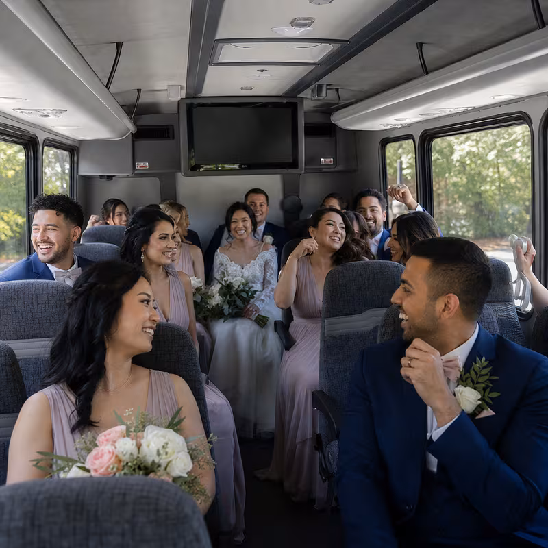 Group boarding a white charter bus for Wedding Transportation transportation in San Jose